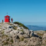 Young backpacker man with trekking poles climbing Sinjal or Dinara 1831 m mountain - the highest of Croatia in the Dinaric Alps on the border between the Republic of Croatia and Bosnia and Herzegovina